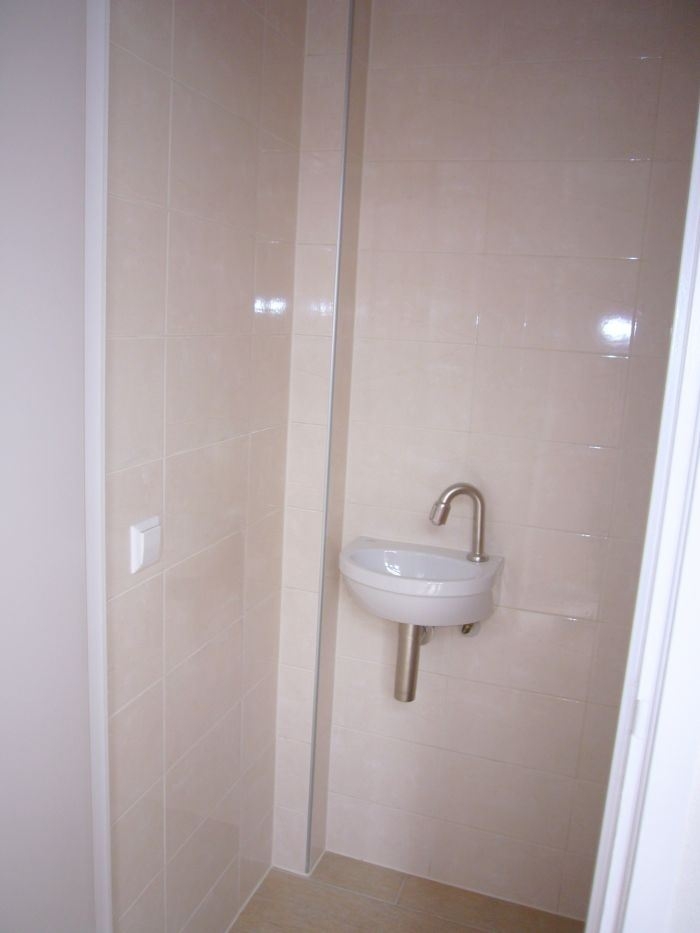 Stukadoors-&-Aannemingsbedrijf-Oskam-toilet-renovatie-toiletvloer-en-wand-betegelen-klein-fonteintje-met-kraan-installeren
